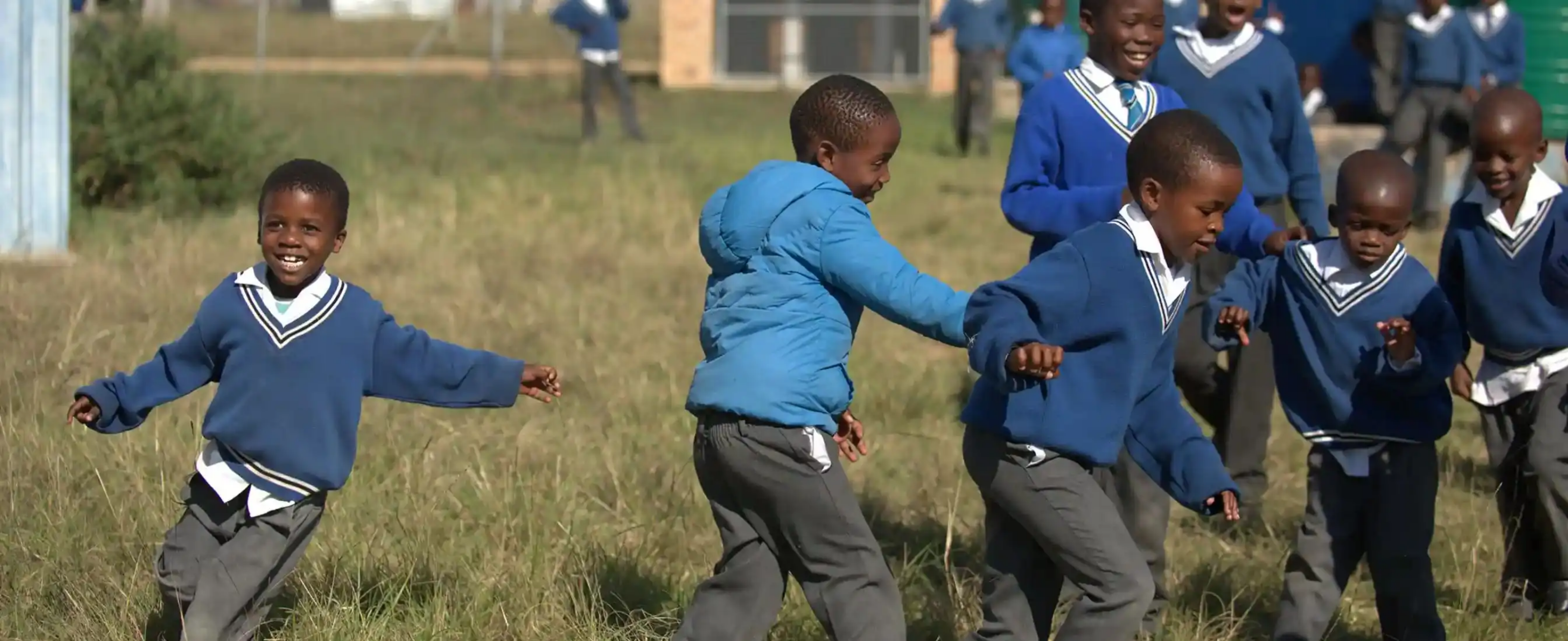 School boys in uniform playing together outside